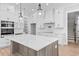A large kitchen island is surrounded by white cabinets, modern lighting, and hardwood floors at 3220 Highway 19, Conway, SC 29526