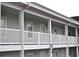 Exterior view of condo building featuring white railings and siding, showcasing a well-maintained building at 4870 Dahlia Ct. # 303, Myrtle Beach, SC 29577
