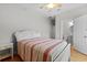 Cozy bedroom with a white bed, ceiling fan, and doorway leading to a bathroom at 504 21St Ave. N, North Myrtle Beach, SC 29582
