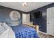 Serene bedroom with a moon wall, wood-frame bed, cozy blankets, and a mounted TV at 5508 Porcher Dr. # 4, Myrtle Beach, SC 29577