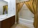Bathroom with a wood vanity and bathtub with shower, complete with elegant shower curtain at 900 British Ln. # 1187, Myrtle Beach, SC 29579