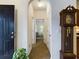Inviting hallway featuring a striking black door, an antique grandfather clock, and an arched entryway to another room at 900 British Ln. # 1187, Myrtle Beach, SC 29579