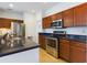Bright kitchen featuring stainless steel appliances, dark countertops, and wood cabinetry at 900 British Ln. # 1187, Myrtle Beach, SC 29579