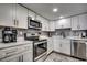 Modern kitchen with white cabinets, marble countertops, stainless steel appliances, and gray backsplash at 1012 N Waccamaw Dr. # 902, Murrells Inlet, SC 29576