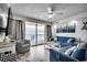 Cozy living room with ocean view, comfortable blue seating, and balcony access at 1012 N Waccamaw Dr. # 902, Murrells Inlet, SC 29576