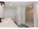 Bathroom featuring a modern vanity, marble-tiled shower with glass door, and wood-look flooring at 106 Governor Boone Ln., Georgetown, SC 29440