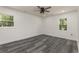 A bright, well-lit bedroom with wood-look flooring and two windows bringing in natural light at 106 Governor Boone Ln., Georgetown, SC 29440