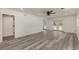 An open-concept living room with wood-look flooring, modern ceiling fan, and double doors to the outside at 106 Governor Boone Ln., Georgetown, SC 29440