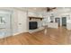Open-concept living room features hardwood floors, a painted brick fireplace, and access to the modern kitchen at 106 Governor Boone Ln., Georgetown, SC 29440