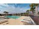 A community pool during the day, with lounge chairs and palm trees overlooking a lake at 257 Venice Way # H 204, Myrtle Beach, SC 29577