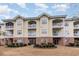 Three-story building with brick and siding, balconies, and landscaping at 4872 Dahila Ct. # 301, Myrtle Beach, SC 29577
