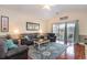 Spacious living room with hardwood floors, comfy seating, and access to balcony at 4872 Dahila Ct. # 301, Myrtle Beach, SC 29577