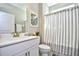 Clean bathroom with white vanity, shower, and striped curtain at 6425 Cascata Dr., Myrtle Beach, SC 29572