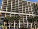 Caravelle Resort exterior shot showcases balconies and palm trees against a blue sky at 6900 N Ocean Blvd. # 614, Myrtle Beach, SC 29572