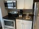 Compact kitchen with stainless steel appliances and white cabinets for a modern look at 6900 N Ocean Blvd. # 614, Myrtle Beach, SC 29572