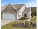 Tan colored exterior of house with two car garage and landscaped yard at 7015 River Bridge Ct, Myrtle Beach, SC 29579