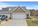 Tan colored exterior of house with two car garage and landscaped yard at 7015 River Bridge Ct, Myrtle Beach, SC 29579