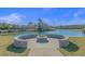 Stone fire pit area with seating next to a pond at 7015 River Bridge Ct, Myrtle Beach, SC 29579