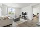 Spacious living room featuring hardwood floors, a comfortable sofa, and a large TV at 9179 Fort Hill Way, Myrtle Beach, SC 29579