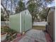 Green storage shed in the backyard with a white fence at 1023 Marthas Way, North Myrtle Beach, SC 29582