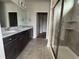 Modern bathroom with dark cabinets, granite counters, dual sinks, glass-enclosed shower with tile surround at 1273 Lady Bird Way, North Myrtle Beach, SC 29582