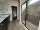 Modern bathroom showcasing a glass shower with tile surround, dual sinks with granite counters, and dark cabinets at 1273 Lady Bird Way, North Myrtle Beach, SC 29582