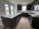 Well-lit kitchen with dark cabinets, white countertops, and stainless steel appliances; island with seating at 1273 Lady Bird Way, North Myrtle Beach, SC 29582