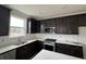 Modern kitchen featuring black cabinets, white backsplash, stainless steel appliances, and ample countertop space at 1273 Lady Bird Way, North Myrtle Beach, SC 29582