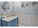 Small bathroom with blue vanity, white tile, and round mirror at 1584 Swing Bridge Way, Myrtle Beach, SC 29588