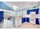 Bright kitchen with white appliances and blue cabinets at 19 Cattail Ct. # 2B, Pawleys Island, SC 29585