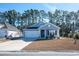 Charming light blue house with white trim and a two-car garage at 2024 Willow Run Dr., Little River, SC 29566