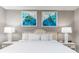 King-size bed with coastal art and white linens at 2801 S Ocean Blvd. # 1131, North Myrtle Beach, SC 29582