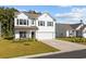 Charming two-story home featuring white siding, black shutters, manicured lawn, and attached two-car garage at 2871 Ellesmere Circle, Myrtle Beach, SC 29579