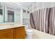 Bathroom with striped shower curtain and wood cabinets at 311 69Th Ave. N # 101, Myrtle Beach, SC 29572