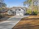 Two-story home with white siding, large windows, and a spacious driveway at 34 Pipedown Way, Pawleys Island, SC 29585