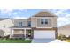 Two-story house with beige siding, stone accents, and a two-car garage at 382 Glacier Way, Conway, SC 29526