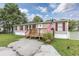 Mobile home with front deck, American flag, and landscaped yard at 3845 Woodridge Circle, Little River, SC 29566