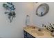 Small bathroom boasts a round mirror and a unique nautical-themed wall decor at 405 Garden Dr. # 106A, Surfside Beach, SC 29575