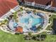 Aerial view of a unique community pool with lush landscaping and a covered seating area at 4210 Coquina Harbour Dr. # A-16, Little River, SC 29566