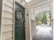 Green front door with wreath, leading to a courtyard with patio furniture at 4323 Lotus Ct. # G, Murrells Inlet, SC 29576