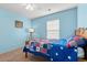 Cozy bedroom painted blue, complete with a wooden bed, lamp and American flag decor at 4451 Livorn Loop # 4451, Myrtle Beach, SC 29579