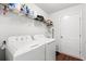 Bright laundry room with washer, dryer, overhead shelving, and a white door at 4451 Livorn Loop # 4451, Myrtle Beach, SC 29579