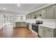 Renovated kitchen features modern appliances and light green cabinets at 47 Byers Trail, Pawleys Island, SC 29585