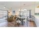 Bright dining area with glass-top table and four chairs, adjacent to living room and kitchen at 4781 Wild Iris Dr. # 304, Myrtle Beach, SC 29577