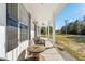 Front porch with white columns, wicker chairs, and a wooden table at 5300 Juniper Bay Rd., Conway, SC 29527