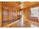 Spacious bedroom with wood walls and floors, featuring multiple windows at 5515 Porcher Dr., Myrtle Beach, SC 29577