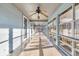 Long screened porch with ceiling fans and windows offering backyard views at 5515 Porcher Dr., Myrtle Beach, SC 29577