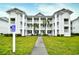 Three-story building with multiple balconies and a manicured lawn at 557 White River Dr. # 12A, Myrtle Beach, SC 29579