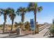 Beach access with wooden walkway and palm trees at 703 3Rd Ave. S, North Myrtle Beach, SC 29582