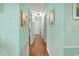 Long hallway with light mint green walls and hardwood floors at 703 3Rd Ave. S, North Myrtle Beach, SC 29582